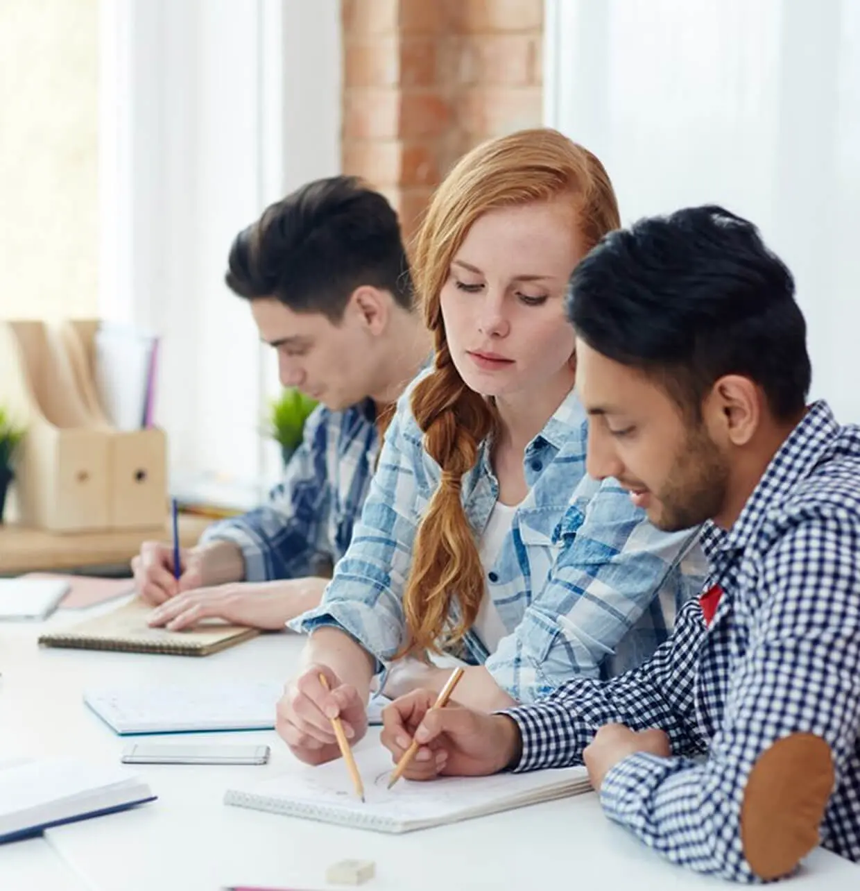 Three people studying at a table together.